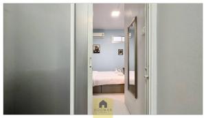a door leading to a bedroom with a bed at Hooman Hostel in Chiang Mai