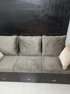 um sofá com quatro almofadas sentado num quarto em Safa Serviced Apartments em Cochin