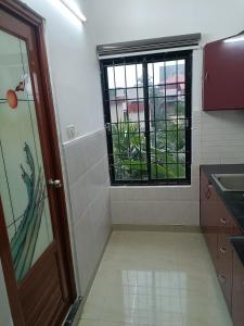 a small kitchen with a window and a door at Safa Serviced Apartments in Cochin