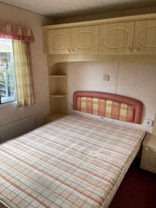 een slaapkamer met een groot bed in een kamer bij Chalet Westmoreland in De Pol