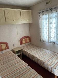 a room with two beds and a window at Chalet Westmoreland in De Pol