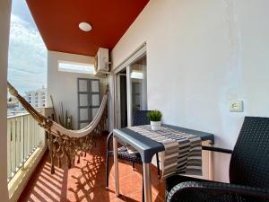 阿爾布費拉的住宿－Varanda do Farol，阳台配有吊床和桌椅。