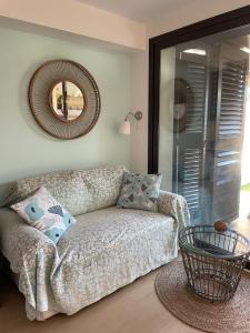 a living room with a couch and a mirror at Beach flat with garden in Castelldefels