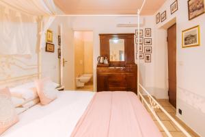 a bedroom with a white bed and a bathroom at La Fabbrica dell'Oro in Asti