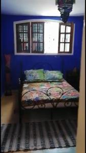 a blue bedroom with a bed in a room at Dar SAADA maison de sylvie in Souira Guedima