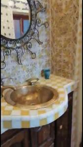 ein Bad mit einem Waschbecken und einem Spiegel in der Unterkunft Dar SAADA maison de sylvie in Souira Guedima