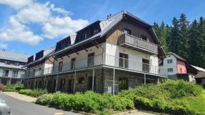 an old building with a balcony on a street at Penzion Dominik in Železná Ruda