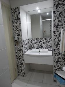 a white bathroom with a sink and a mirror at Bronze Hotel in Gümbet