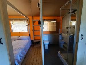 een kleine slaapkamer met een bed en een toilet bij Tente Cottage (6p) Fécamp Etretat in Colleville
