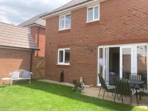 a brick house with a table and chairs in the yard at Mill Meadows in Portskewett