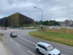 塔尔图Delta 4 Nice apartment 2 big bed的一辆白色汽车,沿着一条有建筑物的道路行驶