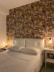 a bedroom with a large white bed with a wall at Falso Pepe Marzamemi Apartment in San Lorenzo