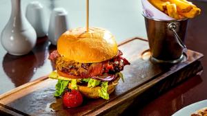 a sandwich on a wooden cutting board with a strawberry at Mulranny Park Hotel in Mulranny