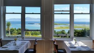 a dining room with two tables and a view of the ocean at Mulranny Park Hotel in Mulranny