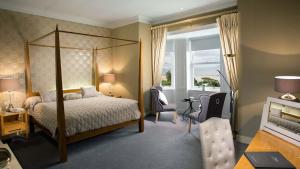 a bedroom with a bed and a desk and a window at Mulranny Park Hotel in Mulranny
