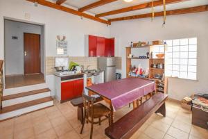 a kitchen with red cabinets and a table in it at House Agava Rei in Tkon