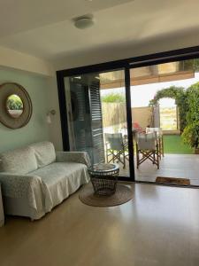 ein Wohnzimmer mit einem Sofa und einer Terrasse in der Unterkunft Beach flat with garden in Castelldefels