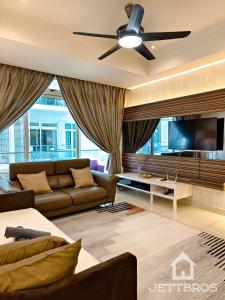 een woonkamer met een bank en een plafondventilator bij KSL D'Esplanade By JettBros Johor Bahru in Johor Bahru