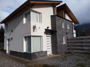 a house with a window on the side of it at ALBANTA Lago Puelo in Lago Puelo