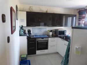 a kitchen with white cabinets and a stove top oven at Lydieline in Wincheringen