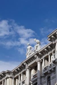 un edificio con dos estatuas encima en Palace Suite, en Trieste