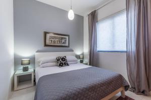 um quarto branco com uma cama e uma janela em Stunning - Seafront 3-Bedroom 6th Floor em Sliema