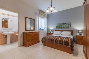 a bedroom with a bed and a sink and a mirror at Stunning - Seafront 3-Bedroom 6th Floor in Sliema