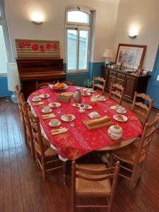 a dining room with a table with a red table cloth at Chambres d'Hôtes L'Insulaire in Saint-Denis-dʼOléron