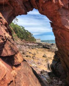 a view of a rocky beach through a rock cave at Ocean View in Cawsand