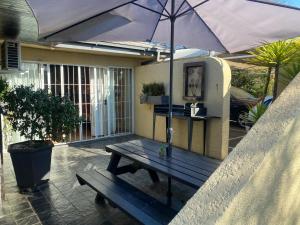 una mesa de picnic con una sombrilla en el patio en Tula@159 en Bloemfontein
