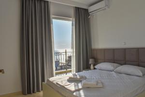 a bedroom with a bed and a large window at PARADISE APARTMENT in Sarandë +58 photos