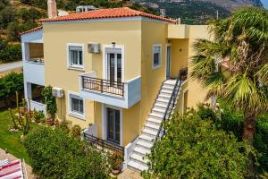 an aerial view of a yellow house with stairs at Plakias River Apartment in Plakias