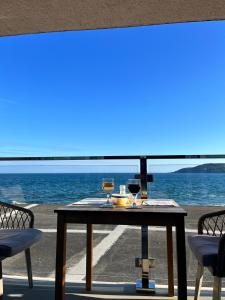 einen Tisch mit zwei Gläsern Wein am Strand in der Unterkunft Ocean View in Cawsand