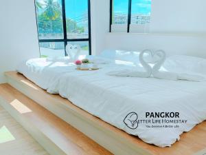 a white bed with two swans on top of it at Pangkor Better Life Cozy Studio-walking 2min to beach,1-4pax in Pangkor