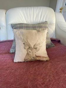 a pillow with a deer head on it on a bed at Beautiful Cottage in the Yorkshire Dales in Leyburn