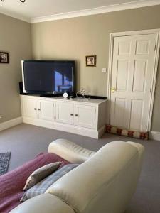 a living room with a flat screen tv and a couch at Beautiful Cottage in the Yorkshire Dales in Leyburn