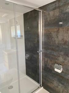 een douche met een glazen deur in de badkamer bij Beautiful Cottage in the Yorkshire Dales in Leyburn