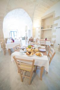 een eetkamer met een tafel met eten erop bij Agriturismo La Palascìa Masseria Agreste in Otranto