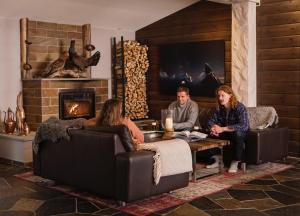 a group of people sitting in a living room with a fireplace at Sagafjord Hotel - by Classic Norway Hotels in Sæbø