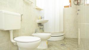 un baño con inodoro y lavabo en Engadin Apartments - Free Parking, en Sarajevo 40 fotos más