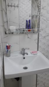 y baño con lavabo blanco y espejo. en Apartment at Narimanov 151, en Ganja
