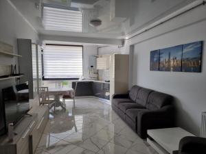 - un salon avec un canapé et une table dans l'établissement Luxury New and Modern Apartments, à Mamaia Nord – Năvodari