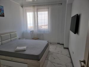 a bedroom with a bed and a tv in a room at Luxury New and Modern Apartments in Mamaia Nord
