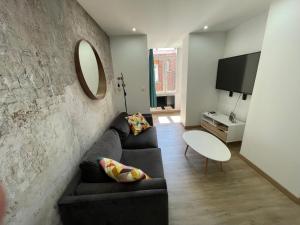 a living room with a couch and a table at La Maison 19 Appartement 4 personnes in Lens