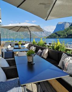 Sagafjord Hotel - by Classic Norway Hotels في Sæbø: فناء به طاولات وكراسي يطل على بحيرة