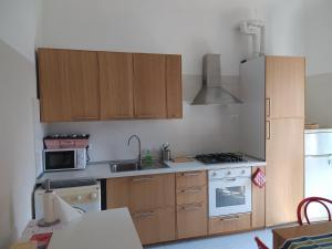 a kitchen with wooden cabinets and a stove top oven at MARE,BIKING, CLIMBING in Finale Ligure