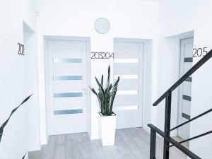 a white hallway with a plant in a white door at Klaster SeaView Hotel in Chornomorsk