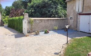 un patio con puerta blanca y pared de piedra en Gîte de la tour de Loire - 65 m2 au pied d'une tour de gué du 17ème siècle, en Mer