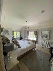 um quarto com uma cama grande e um espelho em Rosedale a charming detached 4 bedroom cottage. em Brixham