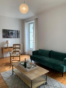 een woonkamer met een groene bank en een salontafel bij Grand appartement de Standing #Hypercentre in Cognac